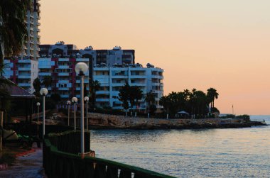 Tipik küçük Türk kasabasının güzel sabah manzarası. Türkiye 'nin Mersin kenti yakınlarındaki Akdeniz kıyısındaki yerleşim yeri. Binalar arasındaki caminin yüksek minaresi.