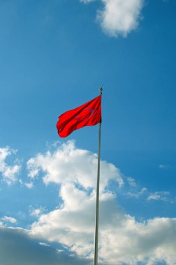 Kırmızı zemin üzerinde Türk Bayrağı, beyaz yıldız ve ay. Kırmızı Türk bayrağı dalgalanıyor. Mavi gökyüzü arkaplanı. 