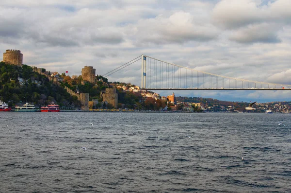 日落时的博斯普鲁斯海峡美景令人惊叹 城市景观 绿山上有古鲁梅利城堡 还有法蒂赫苏丹穆罕默德桥 五彩斑斓的天空 土耳其伊斯坦布尔 — 图库照片