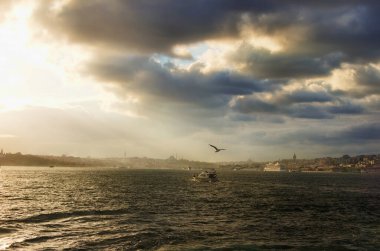 İstanbul Boğazı üzerinde yağmur bulutları (Boğaz veya Boğaz). Arka planda şehrin bulanık silueti var. İstanbul, Türkiye 'de sonbahar.