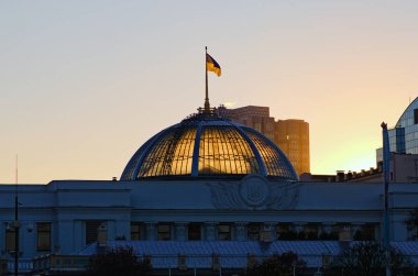 Ukrayna 'nın başkenti Kyiv' de parlamentoda (Ukraynalı Verkhovna Rada) dalgalanan Ukrayna bayrağı. Mavi gökyüzü arka planı. Renkli sonbahar günbatımı.