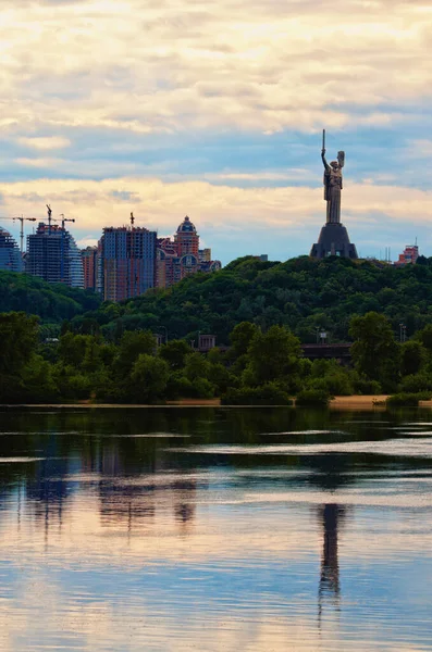 母亲的祖国纪念碑 它是基辅的象征之一 以现代高层建筑为背景 反映在第聂伯河上的纪念碑 多云的天空 — 图库照片