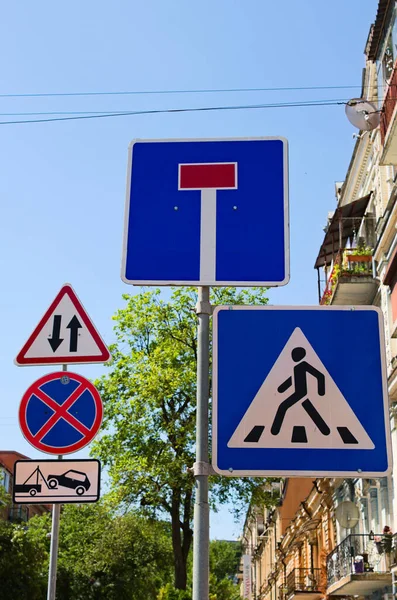 Group of traffic signs on the poles. Concept of road sign in big city. Crosswalk and Dead end signs. Two way traffic, No Stopping and Tow truck is working traffic signs.