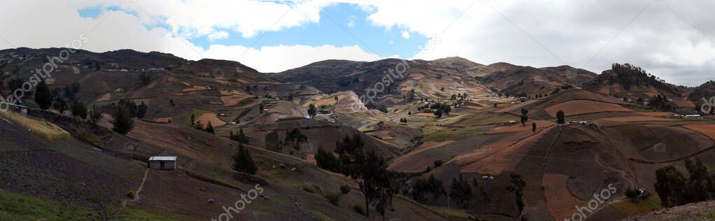 Panorama of mountains and valley with traditional adobe buildings in mountains of Ecuador near Latacunga.