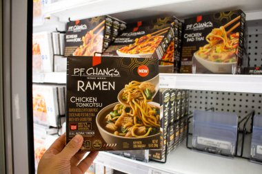 Los Angeles, California, United States - 03-18-2021: A view of a hand holding a box of P.F. Chang's  ramen Chicken Tonkotsu.