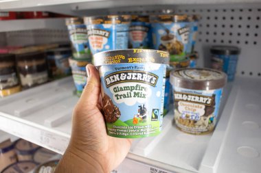 Los Angeles, California, ABD - 03-18-2021: Ben ve Jerry 'nin Glampfire Trail dondurmasını tutan bir elin görüntüsü, yerel bir bakkalda sergileniyor.