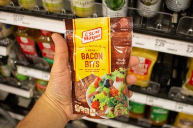Los Angeles, California, ABD - 03-18-2021: Yerel bir bakkalda sergilenen Oscar Mayer Real Bacon Bits paketini tutan bir elin görüntüsü.