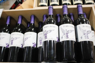 Los Angeles, California, United States - 04-06-2021: A view of several bottles of Montes Carmenere Purple Angel blended red wine 2017, on display at a local grocery store.