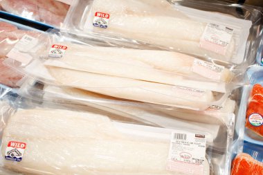 Los Angeles, California, ABD - 04-06-2021: Yerel bir Costco mağazasında sergilenmekte olan Kirkland İmza Vahşi Pasifik Morina filetolarının birkaç paketinin görüntüsü.