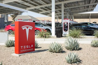 Kettleman City, California, ABD - 09-08-2021: Tesla Superşarj istasyonu için bir işaret ve güneş paneli yapısı.