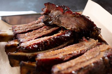 Bir tepside, bir restoranda ya da mutfak ortamında ızgara biftek pirzolasının yakın çekim görüntüsü..