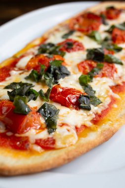 Bir restoranda ya da mutfak ortamında margherita ekmekli pizzanın yakın çekim görüntüsü..