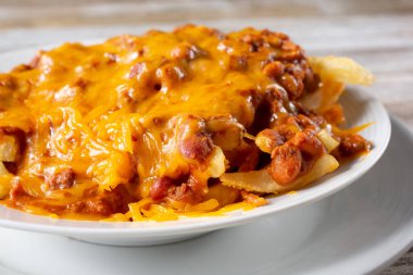 A view of a large bowl of chili cheese french fries.