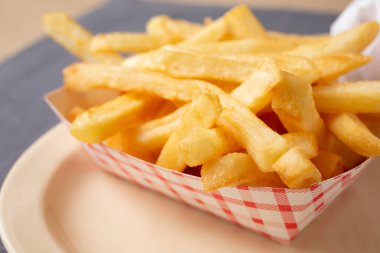 Tabakta, restoranda ya da mutfak ortamında bir karton patates kızartmasının yakın çekim görüntüsü..
