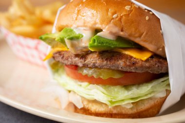 Bir restoranda ya da mutfak ortamında paketlenmiş bir çizburgerin yakın çekim görüntüsü.