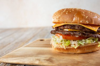 Çerçevenin sağ tarafındaki tahta tahtada duble çizburger manzarası..