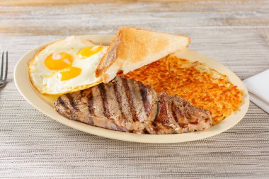 Biftek ve yumurta kahvaltı tabağı manzarası.