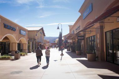 Cabazon, California, ABD - 01-26-2022: Desert Hills Premium alışveriş merkezindeki perakende mağazalarının koridorlarından birinde yürüyen insanların görüntüsü.