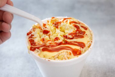 Bir el ve kaşığın bir parça esquitleri kepçelemesi görüntüsü.