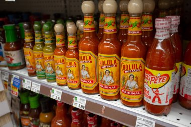 Los Angeles, Kaliforniya, ABD - 10-25-2021: Yerel bir bakkalda görülen çeşitli Cholula acı sos şişeleriyle dolu bir raf manzarası.