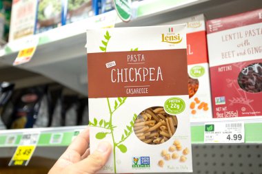 Los Angeles, Kaliforniya, ABD - 10-25-2021: Yerel bir bakkalda sergilenen, bir paket Pasta Lensi Nohut alternatif makarna tutan bir elin görüntüsü.