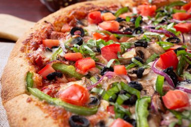 Bir restoranda ya da mutfak ortamında sebzeli pizzanın yakın plan görüntüsü..