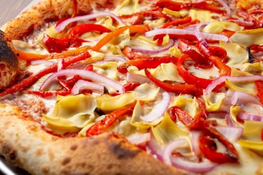 Vejetaryen pizzası, enginar, kırmızı dolmalık biber ve soğan malzemelerinin yakın plan görüntüsü..