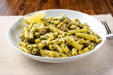 Restoranda ya da mutfak ortamında bir kase pesto makarna..