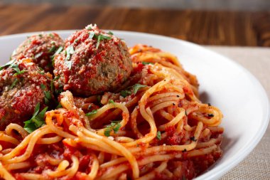 Bir kase spagetti ve köftenin yakın plan görüntüsü..