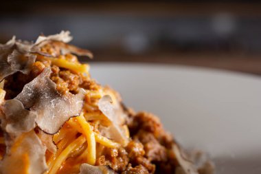 Restoranda ya da mutfak ortamında et soslu ve siyah mantarlı makarna yığınının yakın çekim görüntüsü..