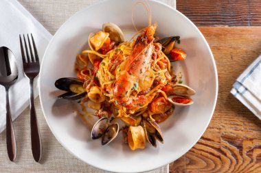 Restoranda ya da mutfak ortamında deniz mahsullü bir tabak tagliolini makarna..