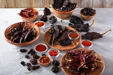 A view of a variety of dried chile peppers. clipart
