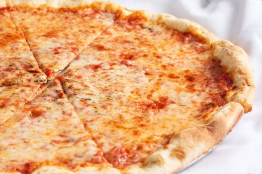 Bir restoranda ya da mutfak ortamında sade peynirli pizza manzarası..