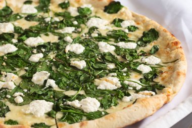 Ispanaklı ve ricotta peynirli rustik pizzanın yakın plan görüntüsü..