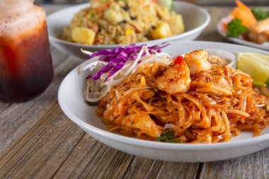 Pad Thai ve Tayland çayının yer aldığı bir masada Tayland mutfağı manzarası.