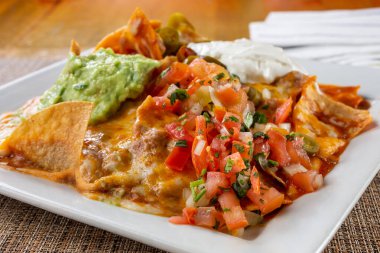 Bir tabak nachos manzarası, bir restoranda ya da mutfak ortamında.