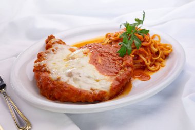 Bir tabak parmesanlı tavuk manzarası, bir restoranda ya da mutfak ortamında.