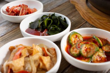 Oi muhim, kimchi, eomuk bokkeum ve miyeok mukus içeren birkaç banchan yemeğinin görüntüsü.