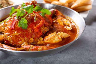 Bir tepsi pişmiş Dungeness yengeci ve baharatlı kırmızı et suyu..