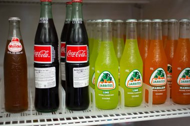 Los Angeles, California, ABD - 10-02-2021: Coca-Cola, Jarritos ve Sidral Mundet gibi popüler soda şişelerinin yer aldığı içecek buzdolabının içindeki manzara.