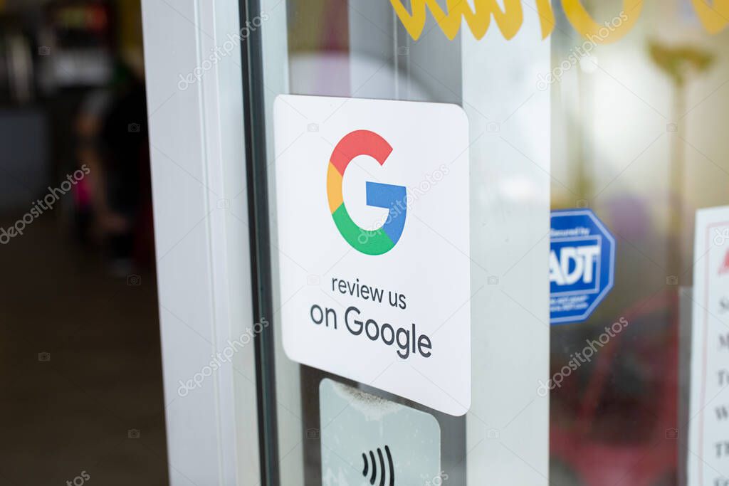 Los Angeles, California, United States - 10-02-2021: A view of a retail store window sticker advertising reviews available on customers to provide reviews on Google.