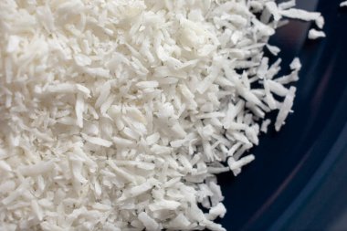 Bir tabak parçalanmış hindistan cevizi gevreğinin yukarıdan aşağıya yakın görüntüsü.