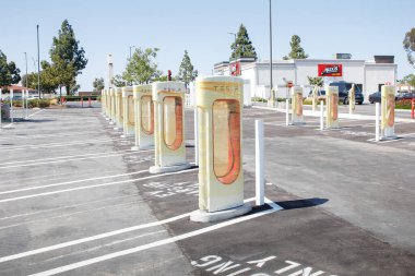 Los Angeles, California, ABD - 04-26-2021: Yeni bir Tesla Supercharger istasyonunda görülen paketlenmiş şarj pompaları manzarası.