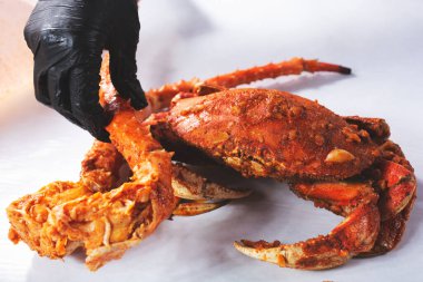 Pişmiş kral yengeç bacağı ve Dungeness yengeci hazırlayan ellerin görüntüsü..