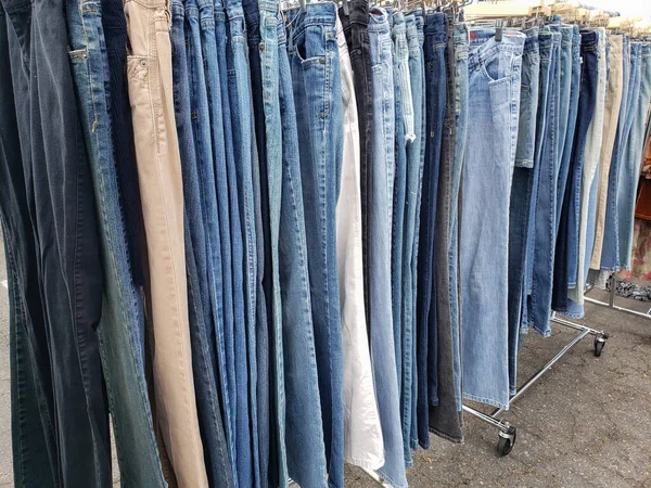 地元の小売店で展示されているいくつかのデニムジーンズ品種でいっぱいのラックの景色 — ストック写真