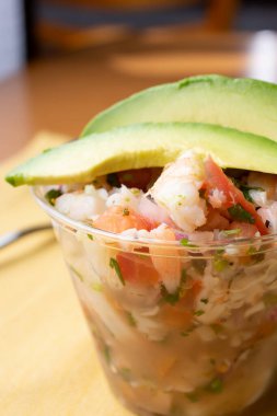 Restoranda ya da mutfak ortamında bir fincan ceviche manzarası.