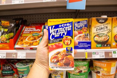 Los Angeles, California, ABD - 05-21-2021: Bir markette sergilenen Vermont Curry Evi 'nin bir paket yiyeceğini tutan bir el görüntüsü.