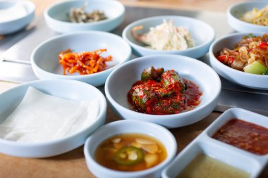 Birkaç çeşit banchan manzarası, Kore mangal restoranında pişirilmiş et dilimleriyle yediğin lezzetli mezeler..