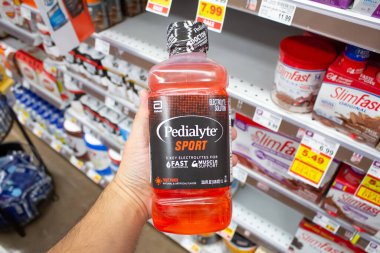 Los Angeles, California, ABD - 08-10-2021: Yerel bir bakkalda sergilenen bir şişe Pedialyte Sport 'u tutan bir elin görüntüsü.