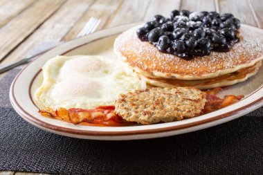 Krepli kahvaltı tabağı manzarası, yumuşak yumurtalar, pastırma şeritleri ve sosisli börek..